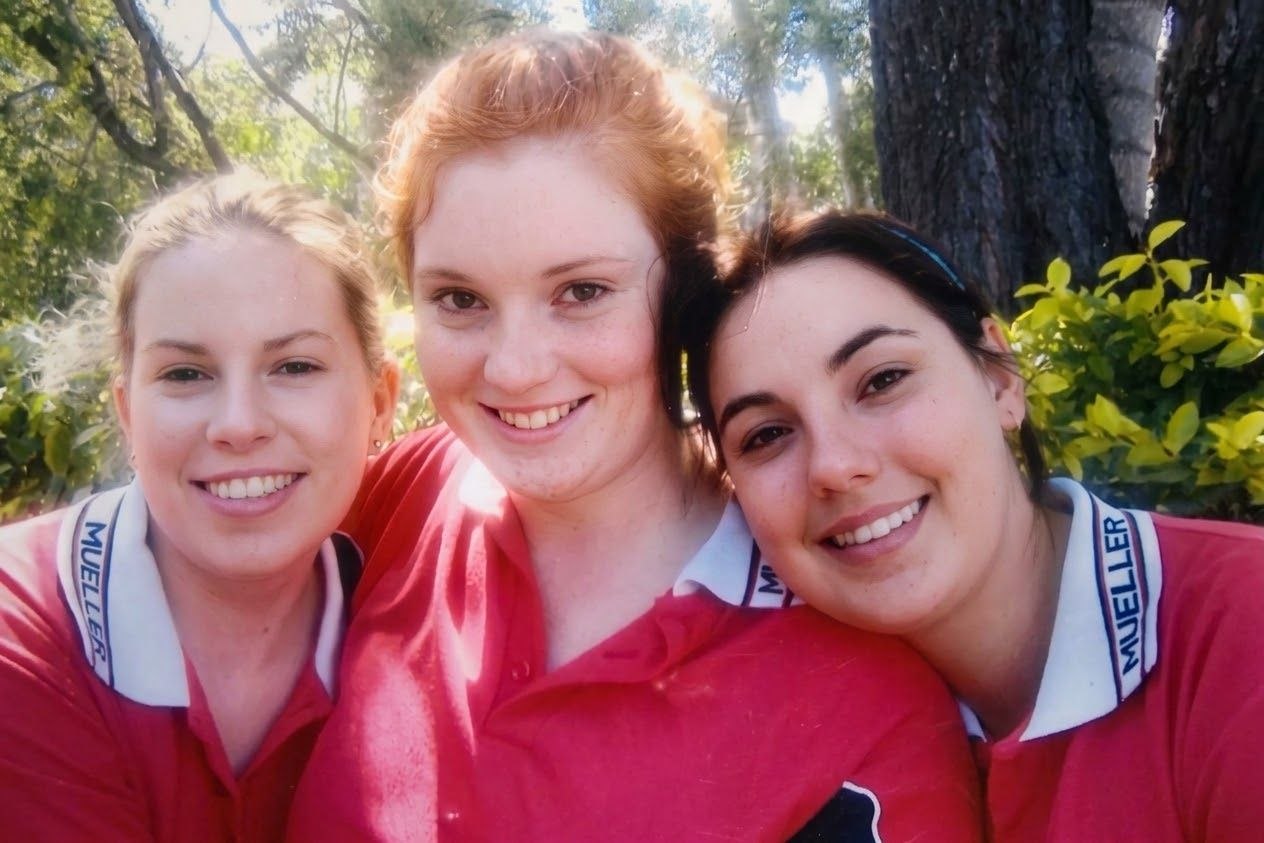 Amy Telfer (far right, light blue headband) with two classmates in Mueller College sports uniform — red polo with white collar. Mueller College, Rothwell, Queensland. Identified by her brother Mark.