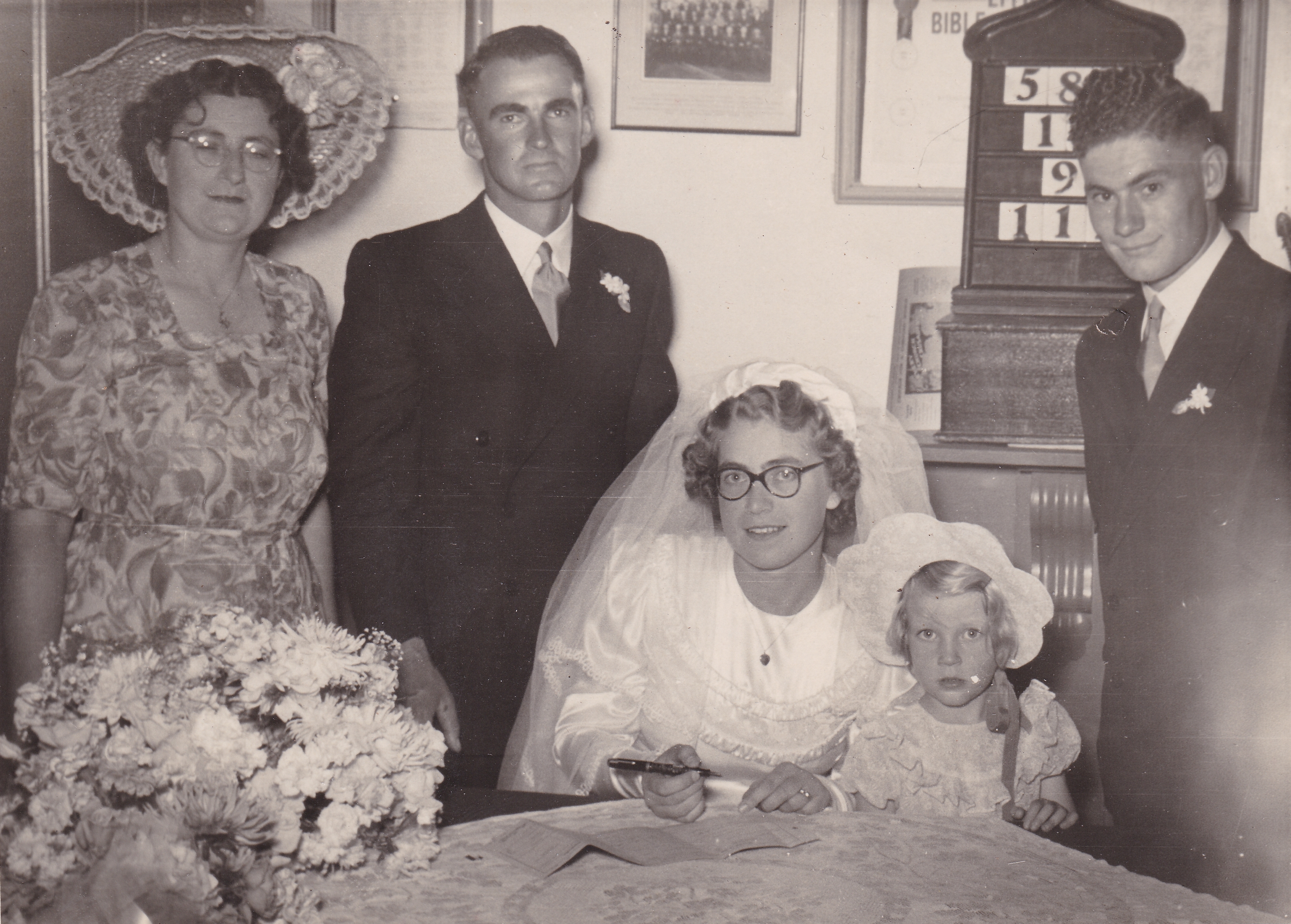 Murray John Telfer and Shirley Edna Parker signing the register, 18 February 1950, Prospect Church of Christ, Adelaide — the bride in round glasses and veil at the register table. Photograph supplied by their eldest son, Daryll William Telfer, 1 October 2026.